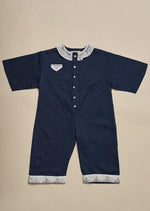 Child's nighttime blue jumpsuit with hand illustrated white edging at neck and ankles.