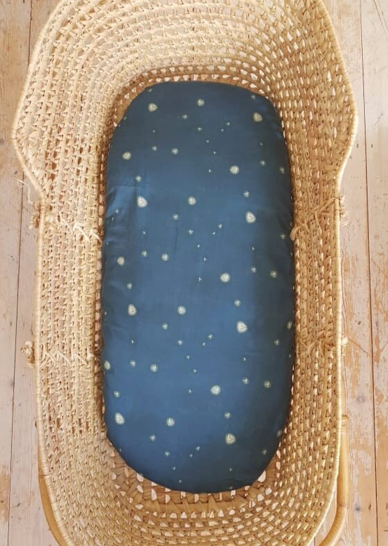 Moses basket with hand illustrated blue 'Glowworms' fitted sheet.