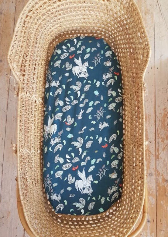 Moses basket with hand illustrated blue 'Tumbling Pegasus' fitted sheet.